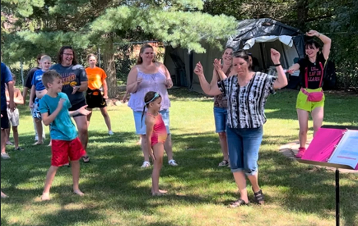 Laughter yoga group playing together outdoors.