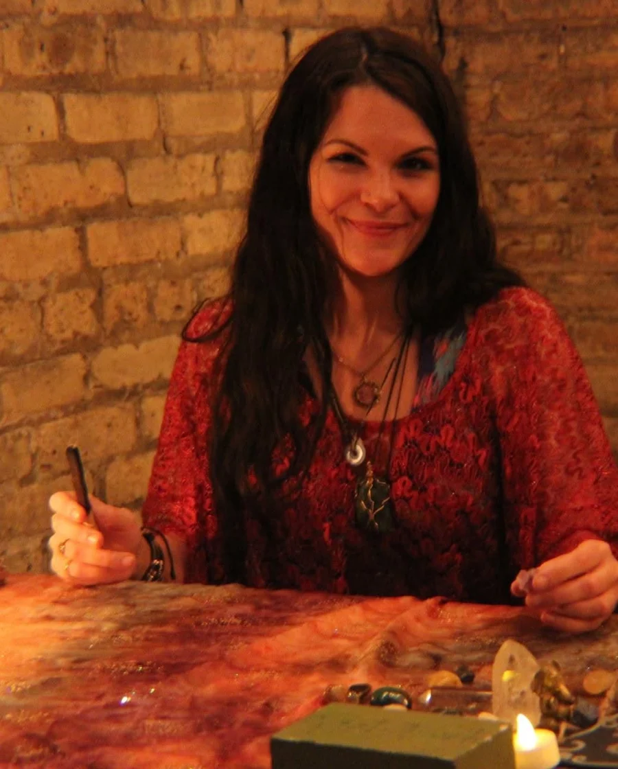 Mel reading tarot cards at a warmly lit table.