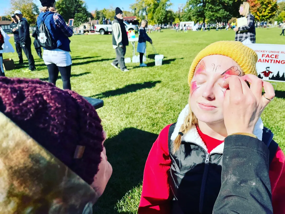 Face painting at a community event in Wisconsin, showing Laughing Llama at work.