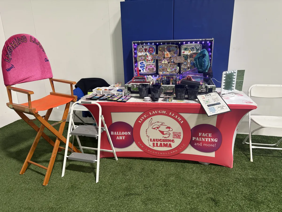 Professional Laughing Llama face painting setup at a Southeastern Wisconsin event.