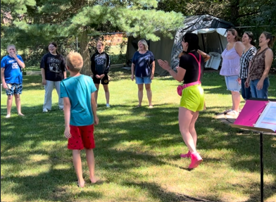 Group participating in a Laughing Llama laughter yoga session outdoors in Wisconsin.